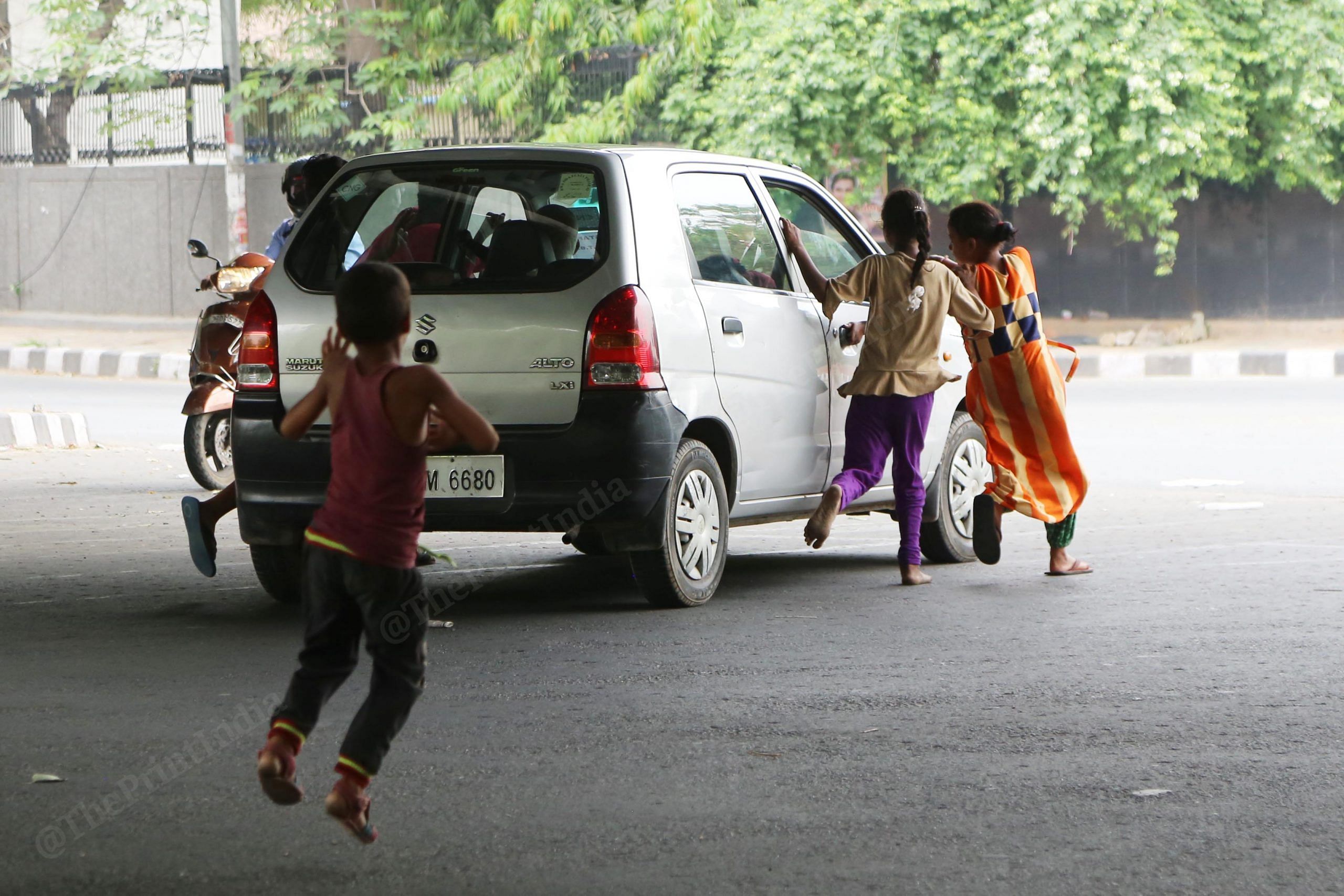 Beggars chase a car for alms in New Delhi | Manisha Mondal | ThePrint