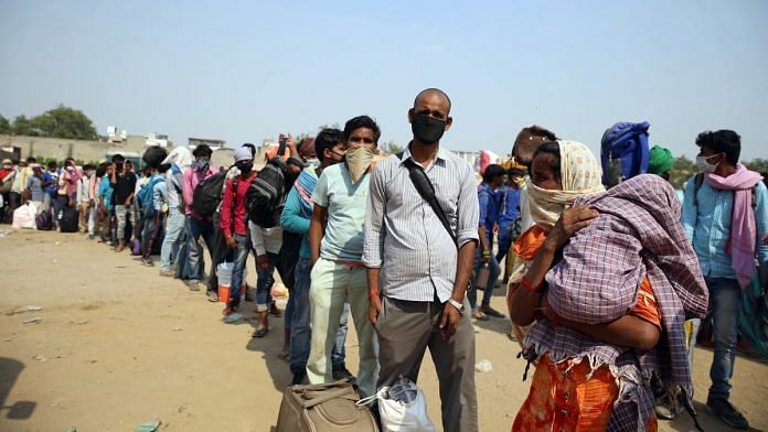 Migrant workers and labourers stand in queues to board buses to their homes on the outskirts of Ghaziabad Monday. | Photo: ANI