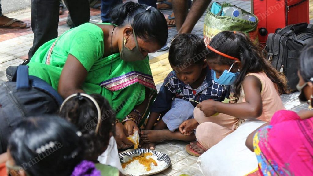 A worker serves food to her children outside the Secunderabad railway station | Suraj Singh Bisht/ThePrint