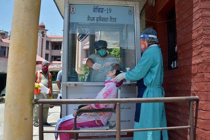 Medics collect a swab sample of a woman for Covid-19 testing at Civil Hospital, during the ongoing nationwide lockdown, in Amritsar, Saturday, June 13, 2020 | PTI