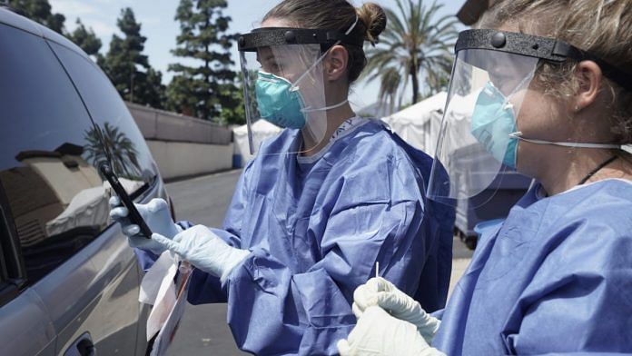 Nurses wearing PPE prepare to collect a nasal swab specimen from a patient at a Covid-19 drive-through testing site at the North Inland Live Well Escondido Center in Escondido, California, US (representative image) | Photo: Bing Guan | Bloomberg