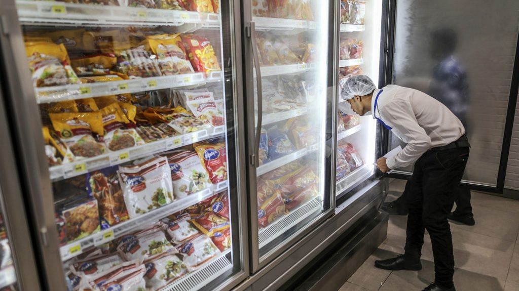 An employee arranges frozen chicken products in a freezer at a Big Bazaar hypermarket, operated by Future Retail Ltd. | Photographer: Dhiraj Singh | Bloomberg