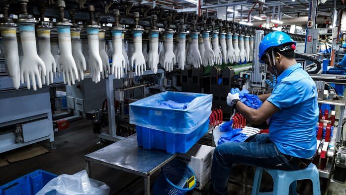 An employee handles latex gloves at a Top Glove factory in Selangor, Malaysia | Bloomberg