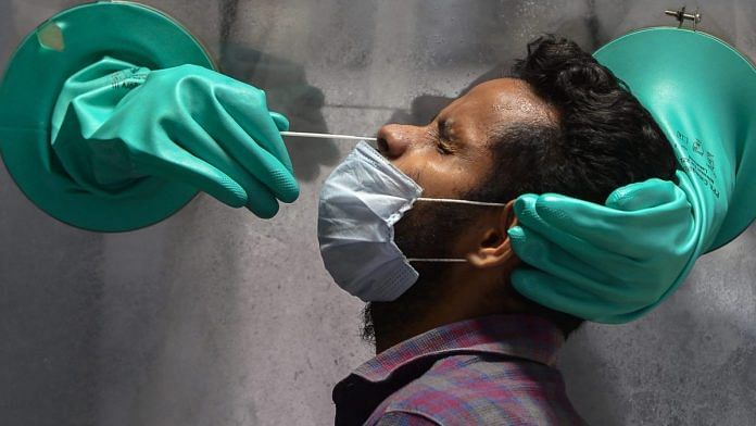 A medic collects swab sample of a suspected Covid-19 patient for a test at a government hospital in New Delhi on 10 June | PTI | Representational image