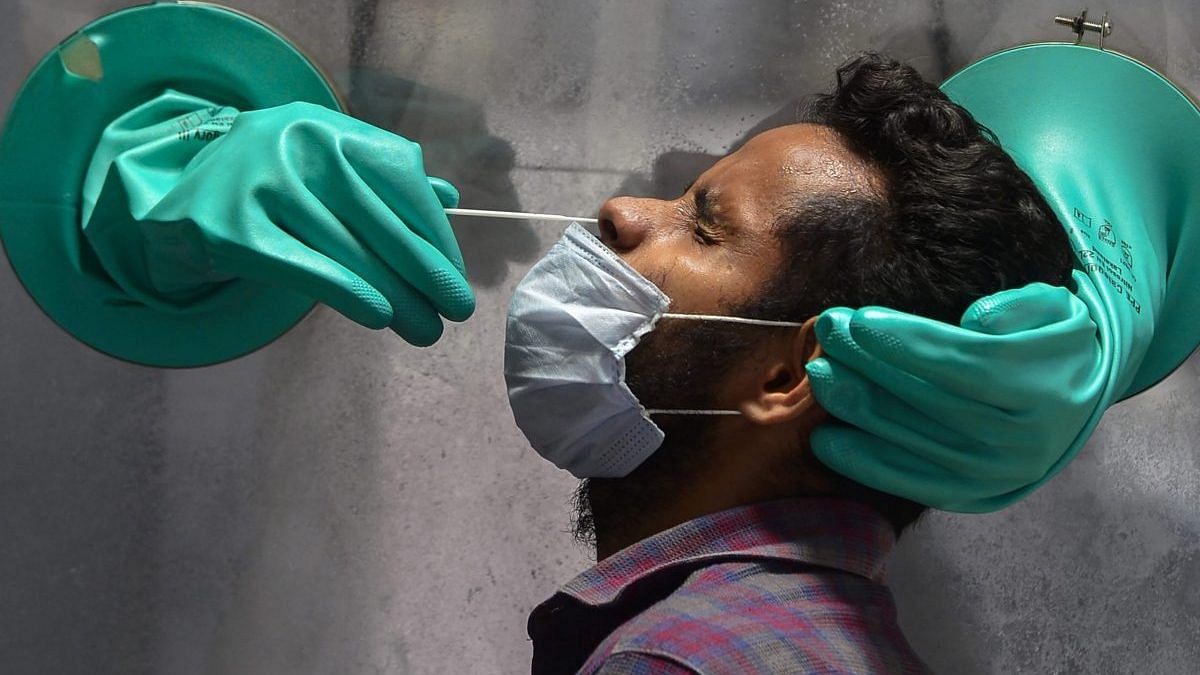 A medic collects swab sample of a suspected Covid-19 patient for a test at a government hospital in New Delhi on 10 June | PTI | Representational image