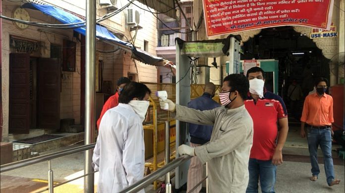 Visitors go through thermal screening at Pracheen Hanuman Mandir, Connaught Place, in New Delhi | Taran Deol