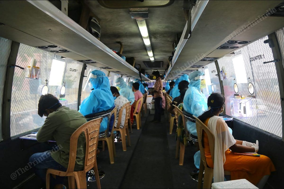 Lab technicians and doctors seated inside a mobile testing facility set up in a bus | Photo: Suraj Singh Bisht | ThePrint