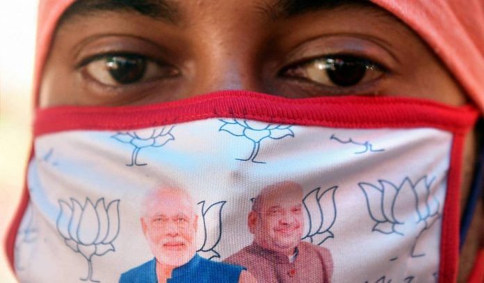 Representational image | A BJP activist wears a mask with pictures of Narendra Modi and Amit Shah, in Kolkata | PTI