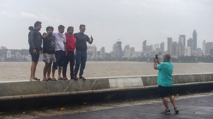 A group of people pose for pictures at Marine drive during Cyclone Nisarga, in Mumbai on 3 June 2020 | Shashank Parade | PTI