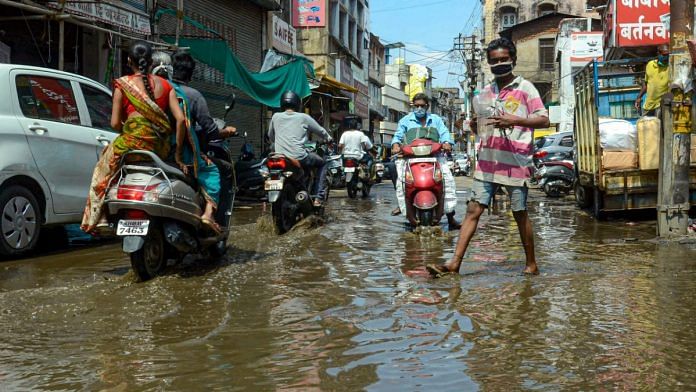 Vehicles pass through a waterlogged street after heavy monsoon rain, in Nagpur on 12 June 2020 | PTI