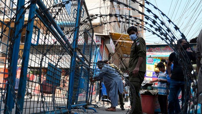 Policemen seal a street at a residential area in Lahore on 17 June