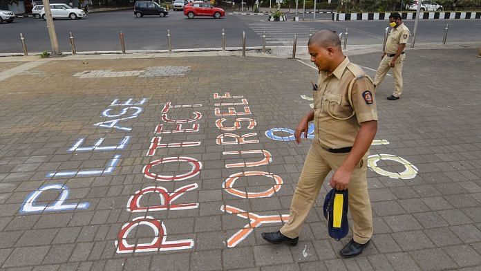 Representational image | Police personnel walk past a message that reads 'Please Protect Yourself And Others' at Marine Drive, during Covid pandemic | PTI