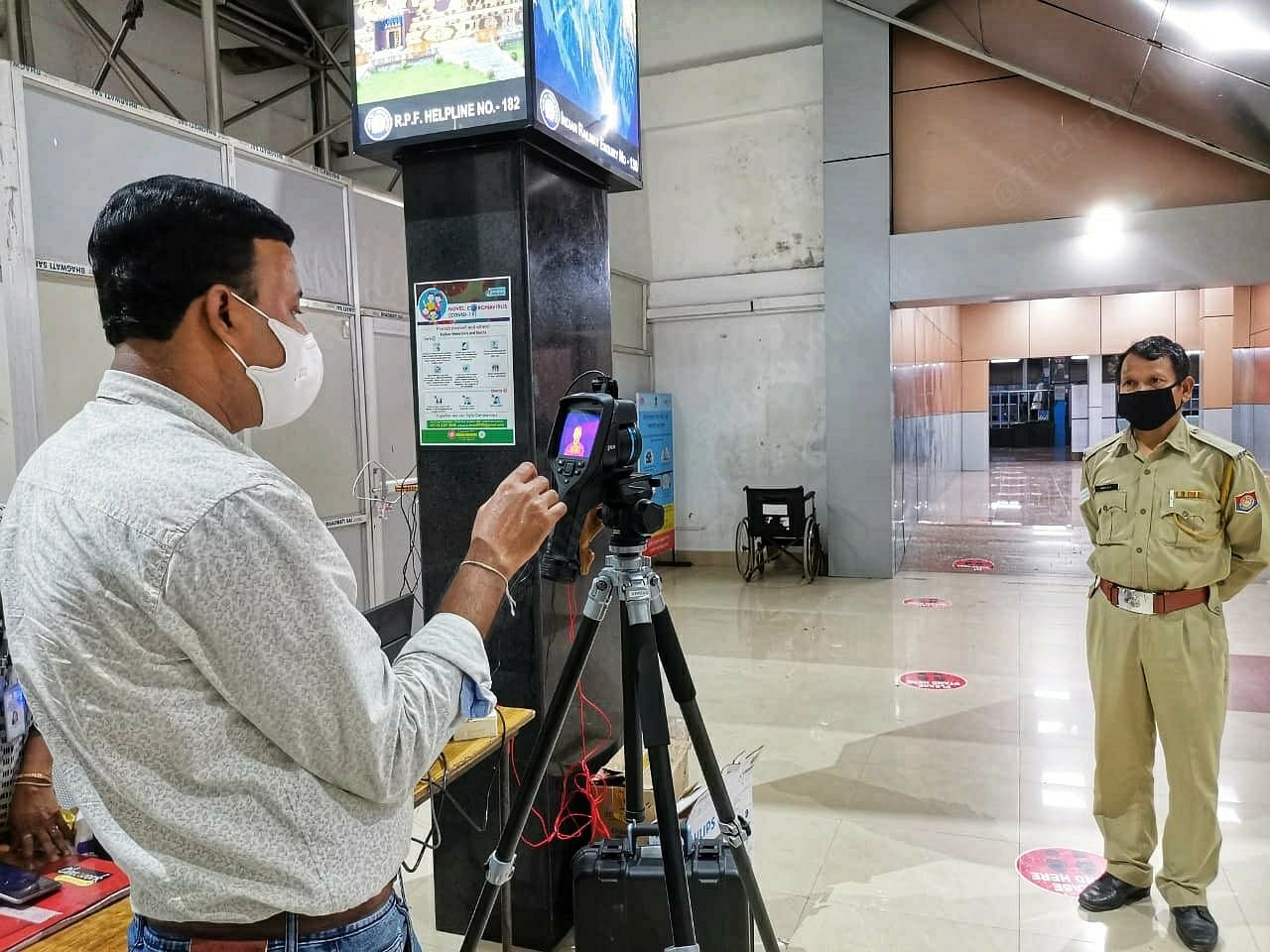 The screening process starts early on, as soon as passengers arrive at the airport and railway stations. A surveillance workers at Guwahati Railway Station checks their temperature and allows them to pass through only if it is below 96 degrees | Photo: Angana Chakrabarti | ThePrint