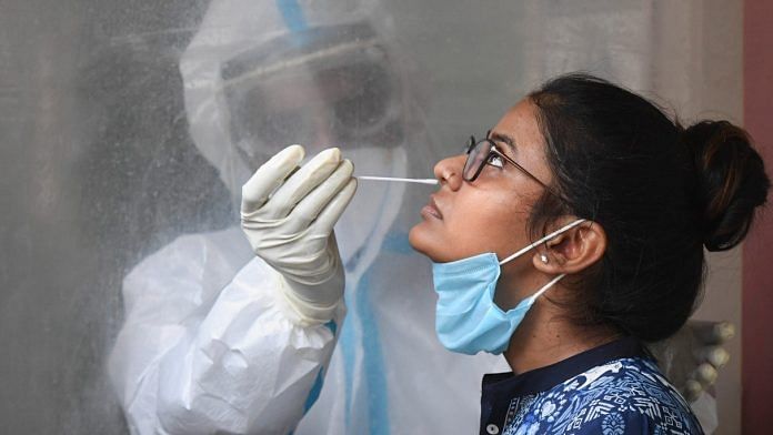 A medic collects a sample of a woman for COVID-19 testing, during the ongoing nationwide lockdown, in New Delhi | Representational image | PTI