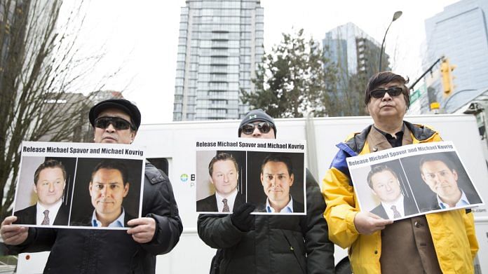 Protesters hold photos of Canadians Michael Spavor and Michael Kovrig, who are being detained by China, outside British Columbia Supreme Court, in Vancouver