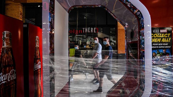 People wear masks as they walk inside a mall west in Florida.