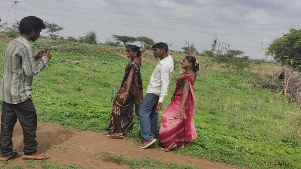 Dinesh Pawar of Jamde, Maharashtra, dances to a 1990s Bollywood song with his two wives while a neighbour films them | By special arrangement