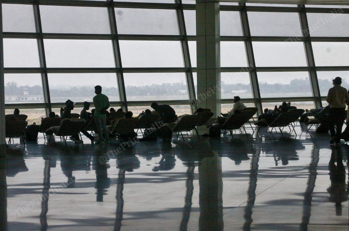 Passengers waiting to board their flight sit on chairs kept at a distance from each other | Praveen Jain | ThePrint