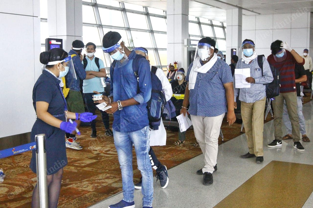 Passengers maintain physical distance from each other as they show their boarding pass and ID cards to the IndiGo crew before boarding the flight | Praveen Jain | ThePrint