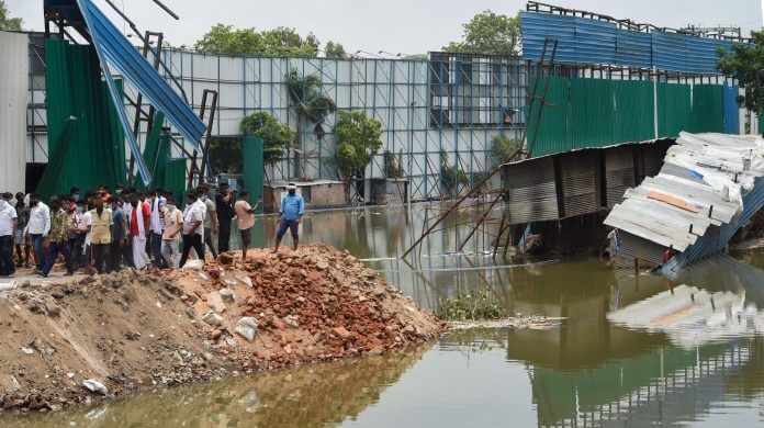 Locals look on at the site of a building collapse, due to monsoon rain, at Anna Nagar in New Delhi, Monday, 20 July, 2020. | Shahbaz Khan/PTI
