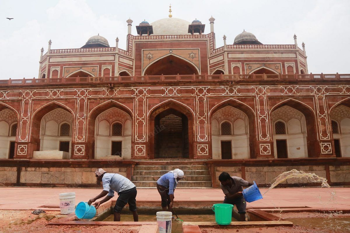Workers at Humayun Tomb clean the rain water logged in one of the fountains | Photo: Manisha Mondal | ThePrint
