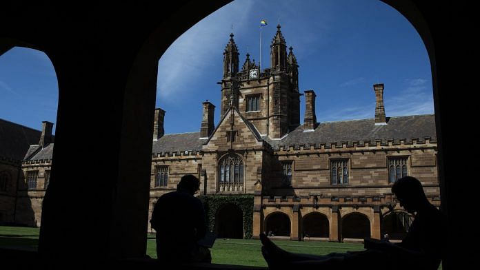 Students sit in the cloister of the quadrangle at the University of Sydney. | Bloomberg