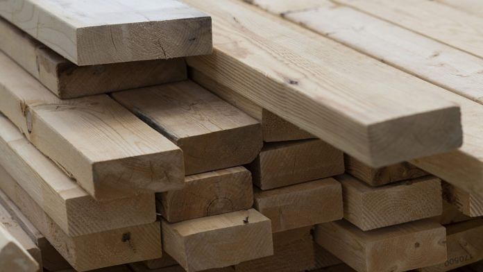 A stack of lumber sits outside a home under construction | Photographer: Ty Wright/Bloomberg