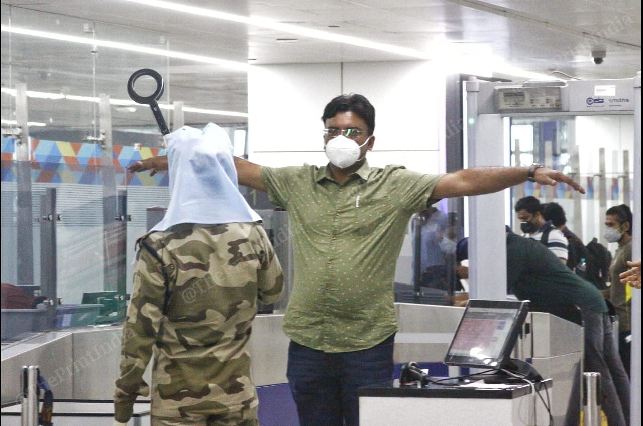 At the airport in New Delhi, a security staffer with an elongated metal detector screens a passenger. The detector was elongated in compliance with social distancing measures | Praveen Jain | ThePrint