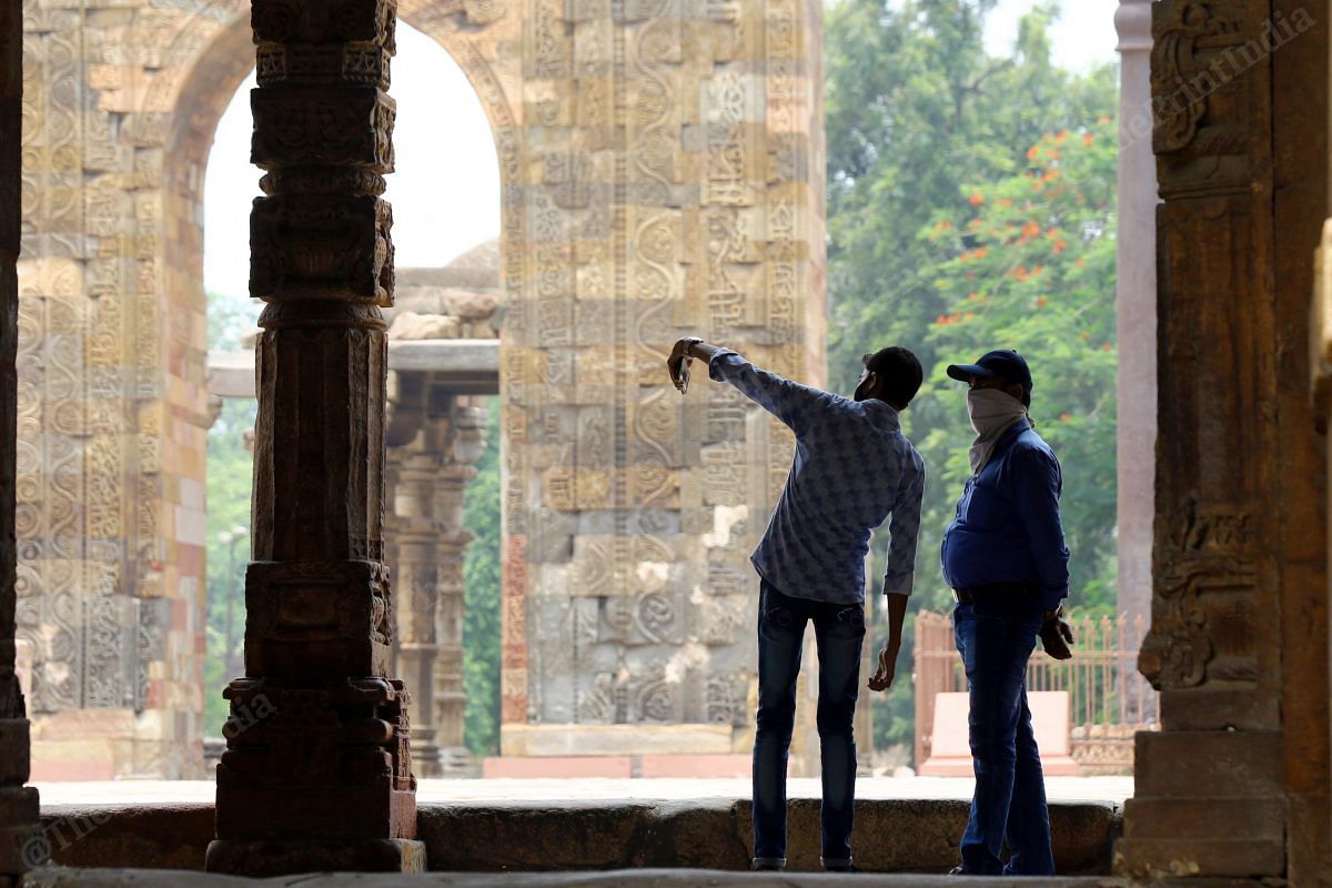 A father son duo click a picture at Qutub Minar | Photo: Suraj Singh Bisht | ThePrint