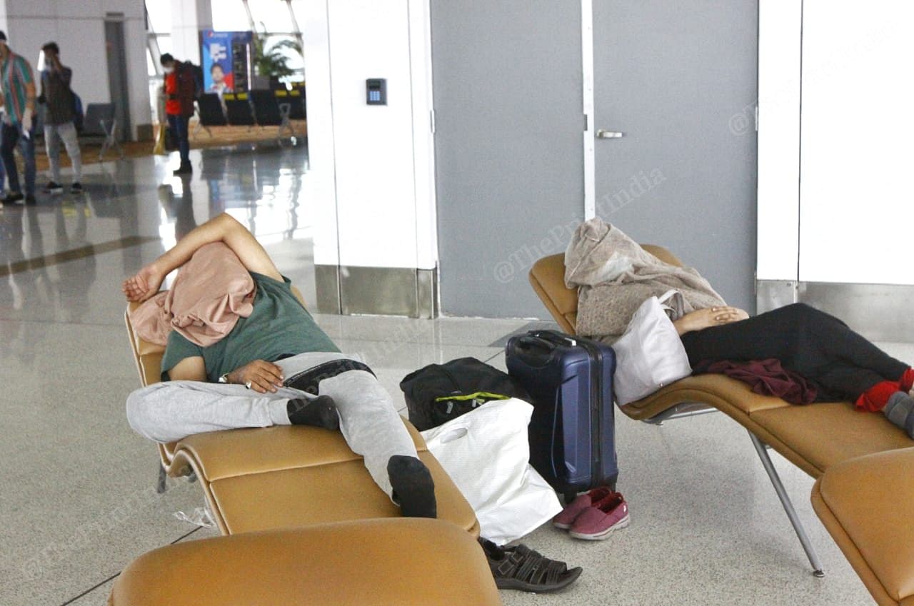 Passengers take nap at the airport covering their entire face | Praveen Jain | ThePrint