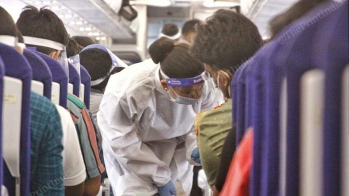 An air hostess wearing a PPE kit gives safety advisory to the passengers | Photo: Praveen Jain | ThePrint