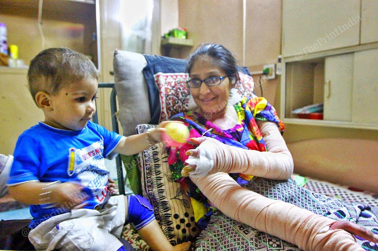 Misbah plays with her son, whom she cannot hold in her arms because of the wounds | Praveen Jain | ThePrint