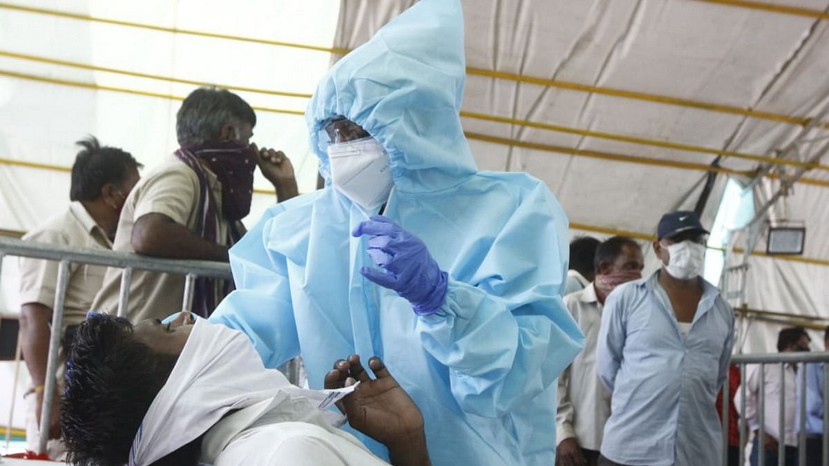 A healthcare worker tests a man for Covid-19 in Ahmedabad | Photo: Praveen Jain | ThePrint