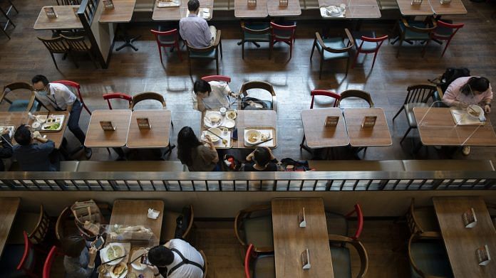 Transparent barriers enforcing social distancing measures are seen on tables at a restaurant in Hong Kong | Bloomberg
