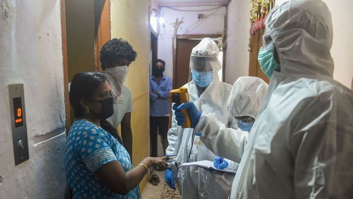 Health workers check the temperature of a woman during a Covid-19 screening drive at a residential building in Dharavi in Mumbai | PTI File Photo