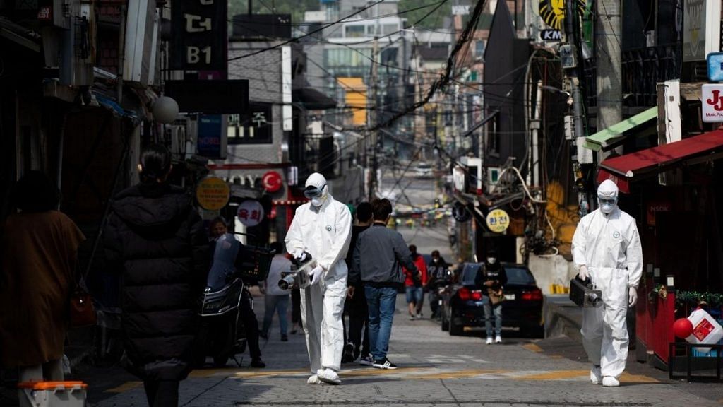 Workers spray disinfectant following a flareup in the Itaewon neighborhood in Seoul in July, 2020. | Bloomberg