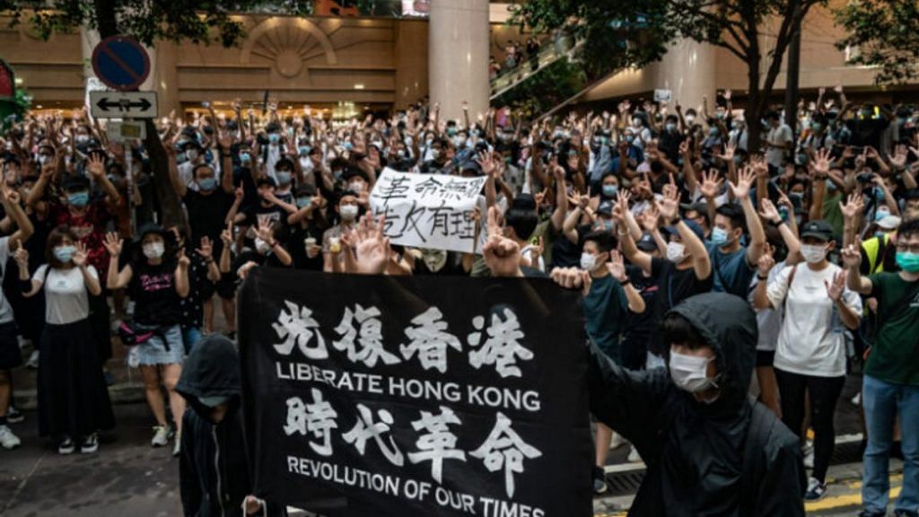 Protesters hold up a 'Liberate Hong Kong! Revolution of our time!' banner, now illegal under the law in Hong Kong. | The Pulse/Twitter