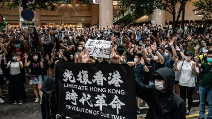 Protesters hold up a 'Liberate Hong Kong! Revolution of our time!' banner, now illegal under the law in Hong Kong. | The Pulse/Twitter