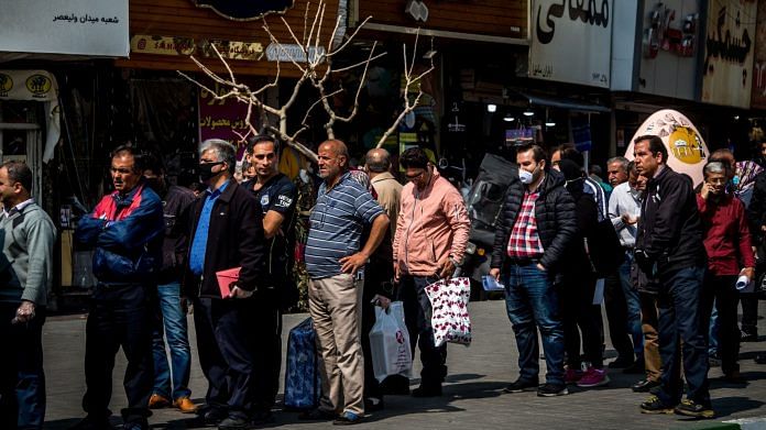 Peoplequeue up to buy surgical gloves in Tehran, Iran, but many don't wear masks | Photographer: Ali Mohammadi | Bloomberg