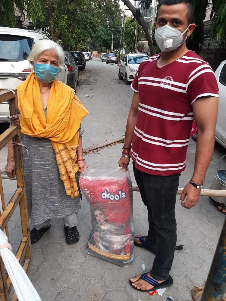 Delhi resident Geeta, receiving a 22 kg bag from a PFA volunteer for feeding the stray animals. | Photo: Special arrangement
