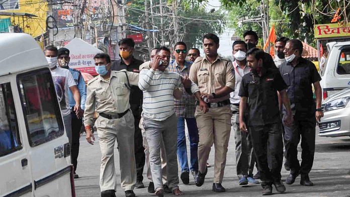 File photo of gangster Vikas Dubey being apprehended by police personnel in Ujjain on 9 July 2020 | PTI