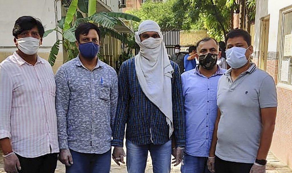Delhi Police with an alleged ISIS operative (Centre) after arresting him last night from central Delhi's Ridge Road area on 22 August | PTI Photo
