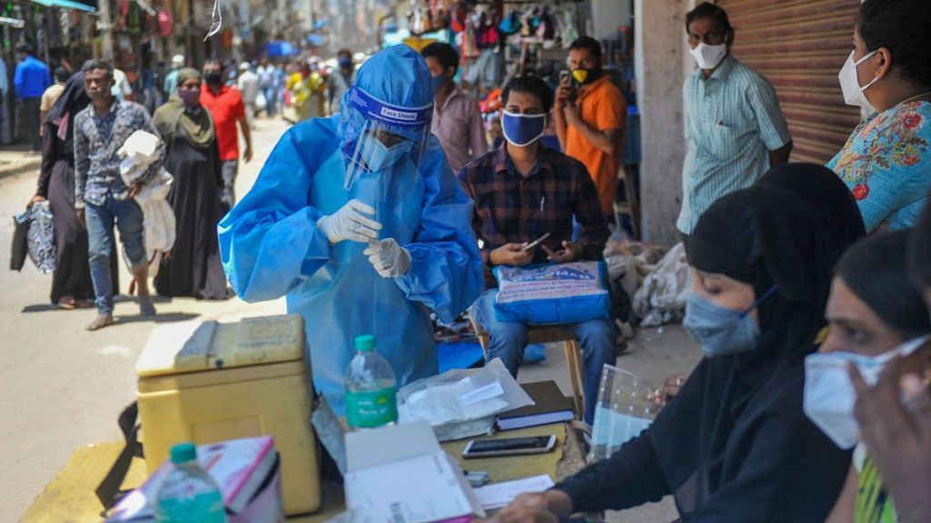 A medic in PPE collects samples for Covid-19 tests in Bengaluru on 25 August 2020 | PTI