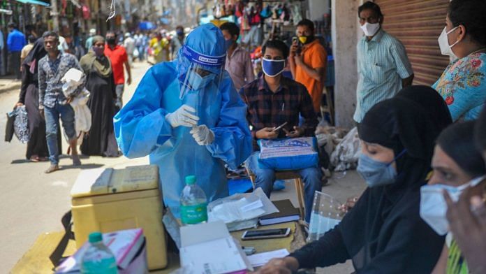 A medic in PPE collects samples for Covid-19 tests in Bengaluru on 25 August 2020 | PTI