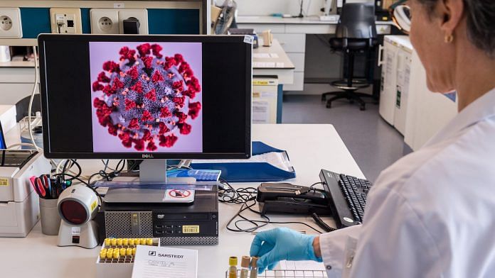 A magnified coronavirus germ is displayed on a monitor during coronavirus patient sample detection tests in the virology research labs at UZ Leuven university hospital in Leuven, Belgium | Bloomberg Photo