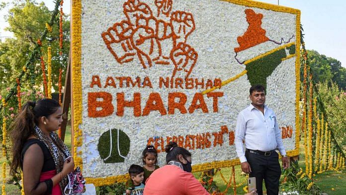 People pose for selfies and pictures in front of an NDMC board decorated with flowers on the occasion of 74th Independence Day, in New Delhi, on 15 August 2020 | Kamal Kishore | PTI
