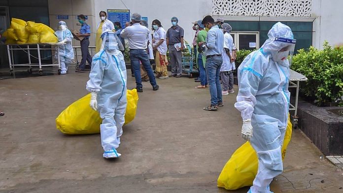 Health workers dispose medical waste at Calcutta Medical College Hospital, during the biweekly COVID-19 lockdown, on 27 August 2020 | Swapan Mahapatra | PTI