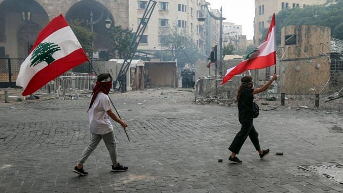 Protesters wave Lebanese national flags during a demonstration close to parliament in Beirut, Lebanon, on Saturday, Aug. 8, 2020 | Bloomberg file