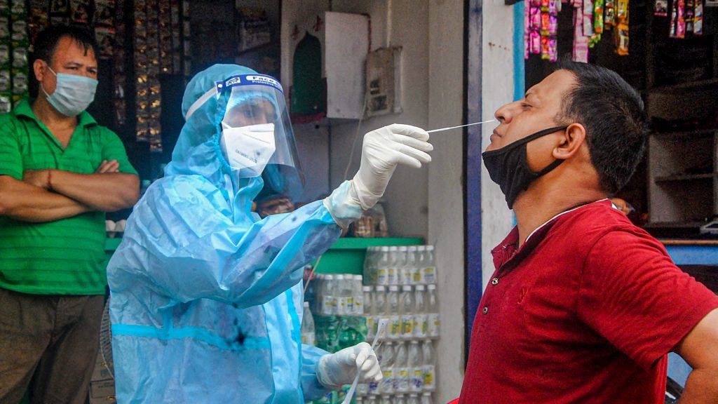 A health worker collects sample of a person for Covid-19 test via Rapid Antigen Testing, at Manipuri Basti in Guwahati | PTI