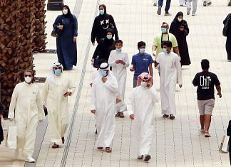 Kuwaitis wearing face masks walk inside the re-opened Avenues Mall, the country's largest shopping centre, on June 30 | Photo: Yasser Al-Zayyat/AFP/Getty Images via Bloomberg